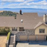 Front approach of custom home with stone accents 3 car garage