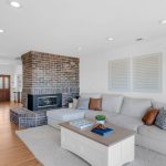 Cozy family room space featuring brick fireplace and comfortable couch seating in San Jose.