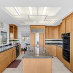 Kitchen interior showing granite countertops, island, and high-end built-in appliances in San Jose.