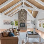 Spacious living room with vaulted exposed beam ceilings and stone fireplace in San Jose CA.