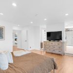 Primary suite bedroom with hardwood flooring and TV setup in luxury San Jose real estate.