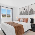 Guest bedroom with bed, mountain wall art, and bright window in San Jose 5-bed home.