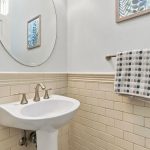 Powder room at 646 Luna Park Drive featuring pedestal sink and tile wainscoting
