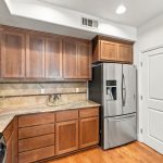 Kitchen storage, wood cabinetry and stainless steel refrigerator