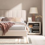 Restful bedroom featuring neutral bedding, soft natural lighting, warm wood furniture, and calming interior design.